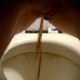 A woman has some nasty diarrhea while standing above a toilet. It looks as if she is pissing out of her ass!